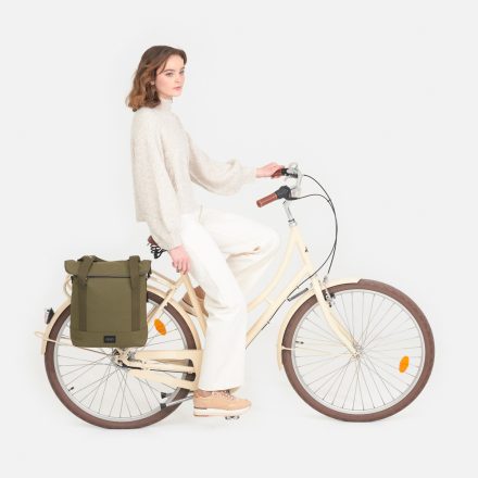 city bike tote olive kvinna cyklar med väskan fäst på pakethållaren