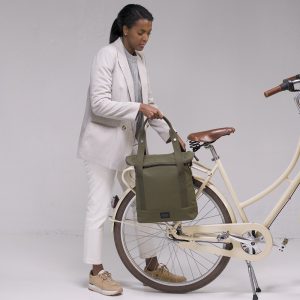 city bike tote olive kvinna står vid cykel och lyfter av väskan från pakethållare