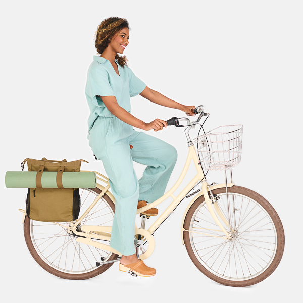 https://weathergoods-1def4.kxcdn.com/wp-content/uploads/2022/05/weathergoods-bicycle-bag-wkndr-totepack-gold-with-yoga-mat-woman-cycling-with-bag-on-bike.jpg