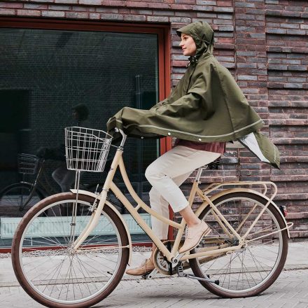 woman cycling wearing imbris rain poncho green