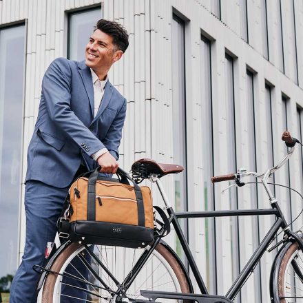 man removing urban briefcase toffee from bike