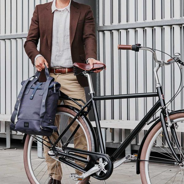 man standing with bike removing city bikepack blue from bike
